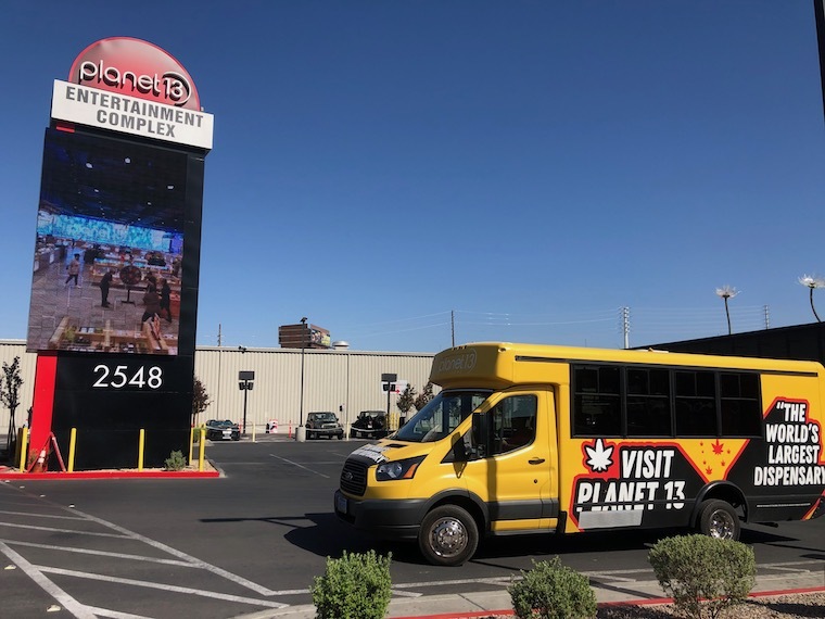 Planet13 yellow shuttle bus and parking lot