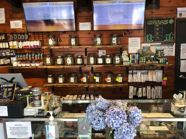 Shelves with glass jars filled with different strains of cannabis 